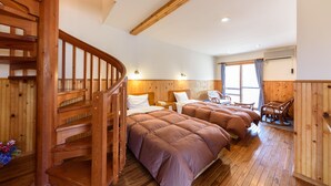 Un escalier en bois mène à une chambre à coucher qui contient deux lits, une chaise et un fauteuil à bascule.