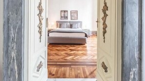Une chambre à coucher avec un lit, deux tables de chevet et une commode.
