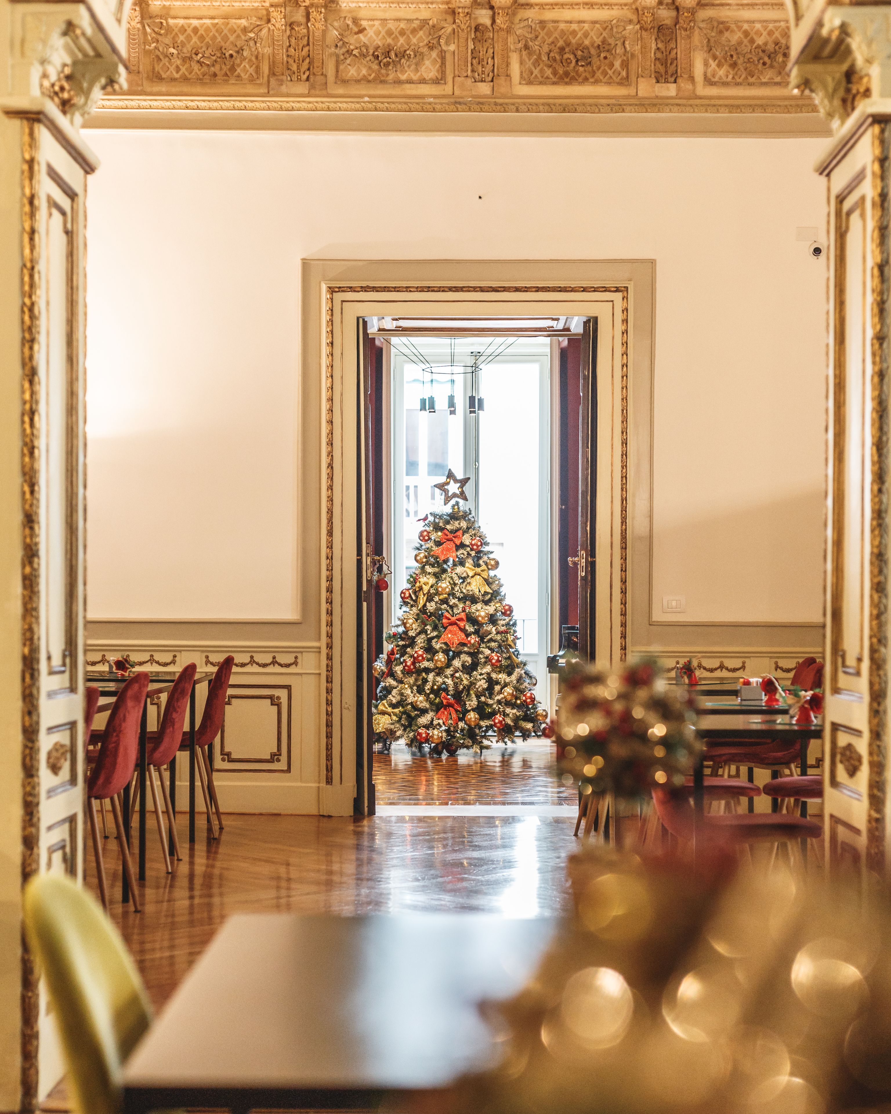 Ein Essbereich mit einem Weihnachtsbaum, Holzsesseln und einem Tisch.