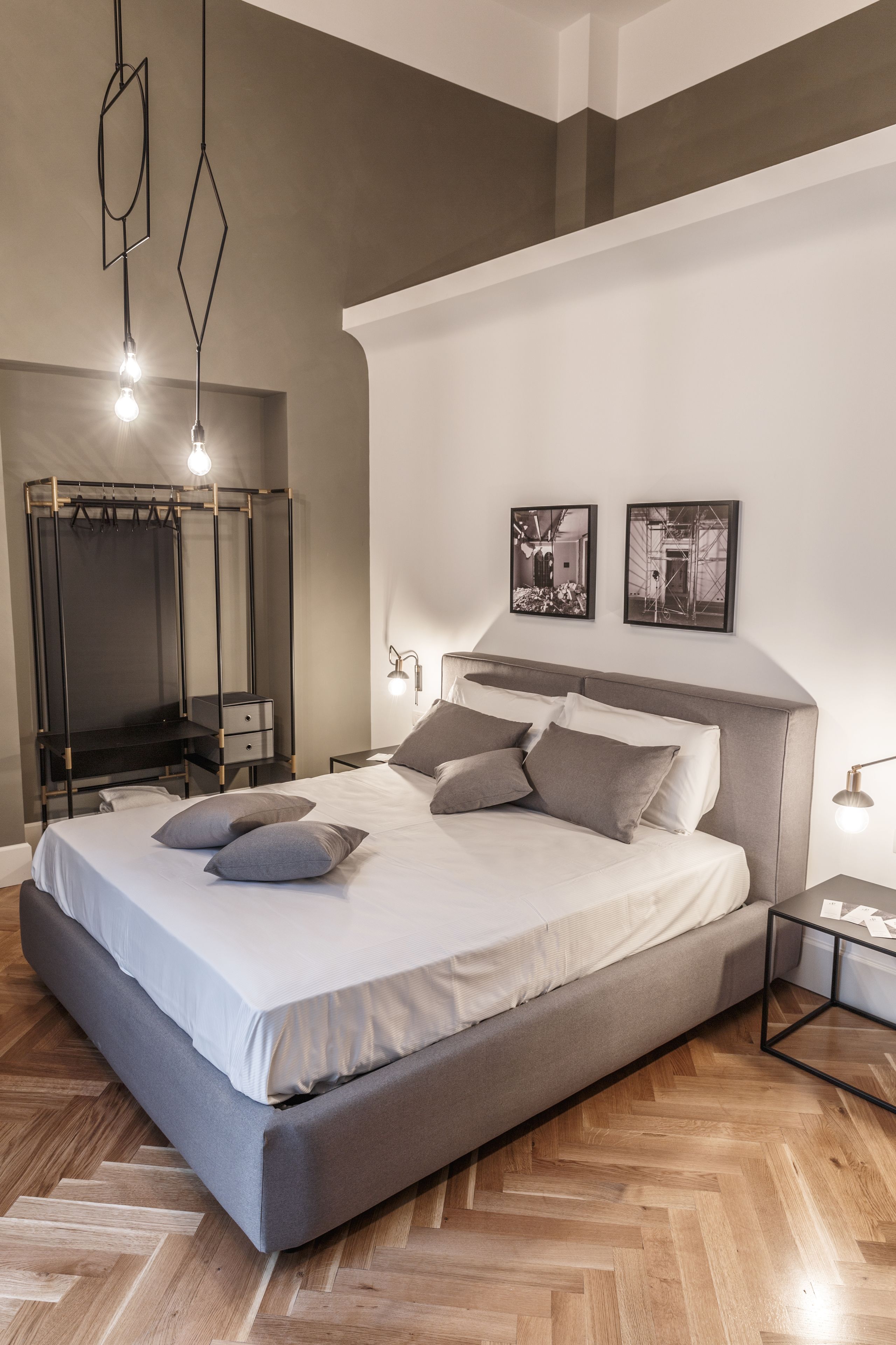 A modern bedroom with a large bed, a wardrobe, and a mirror.