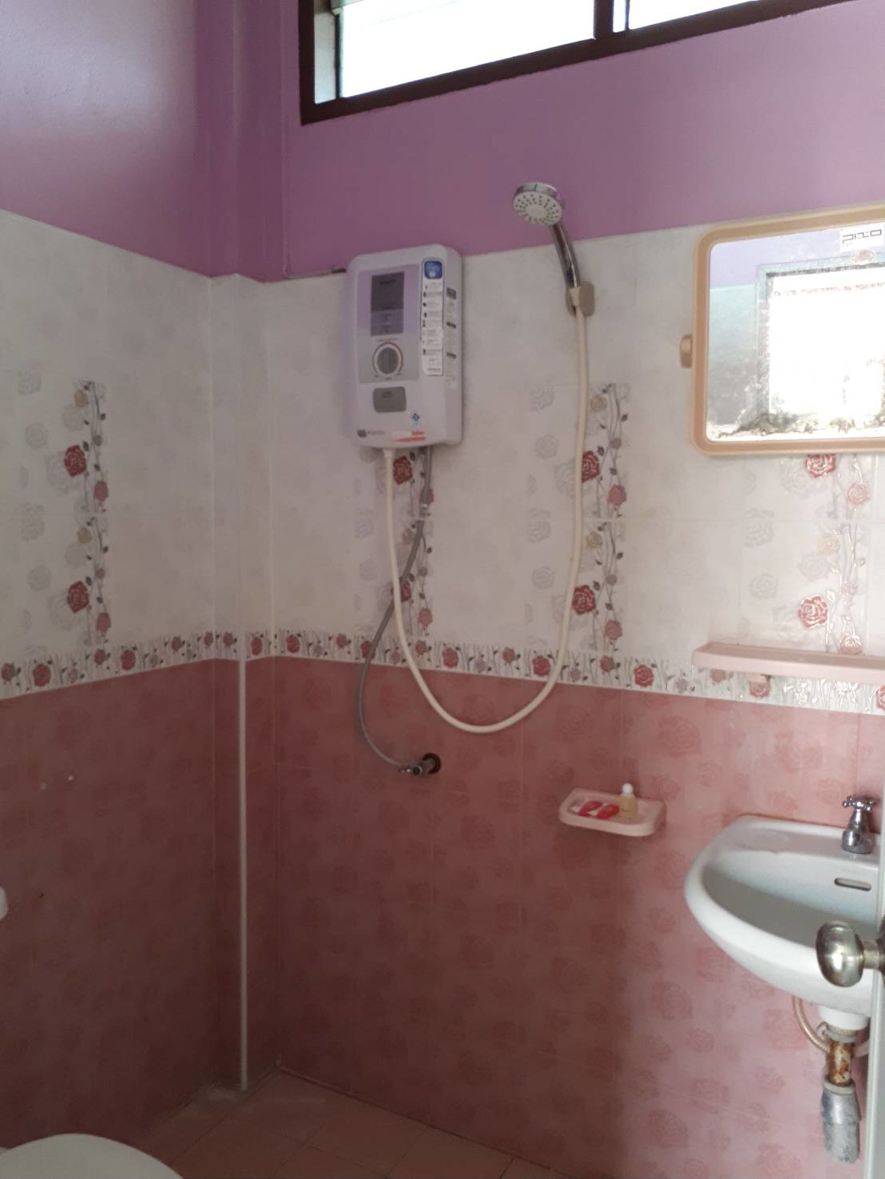 A bathroom with a shower, a sink, and a mirror.