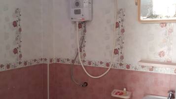 A bathroom with a shower, a sink, and a mirror.