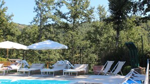 A pool area with lounge chairs and umbrellas. - Borgo Caiano Country Inn (Castel San Niccolo)