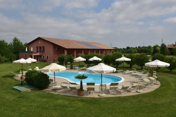 Een buitenzwembad, ligstoelen bij het zwembad