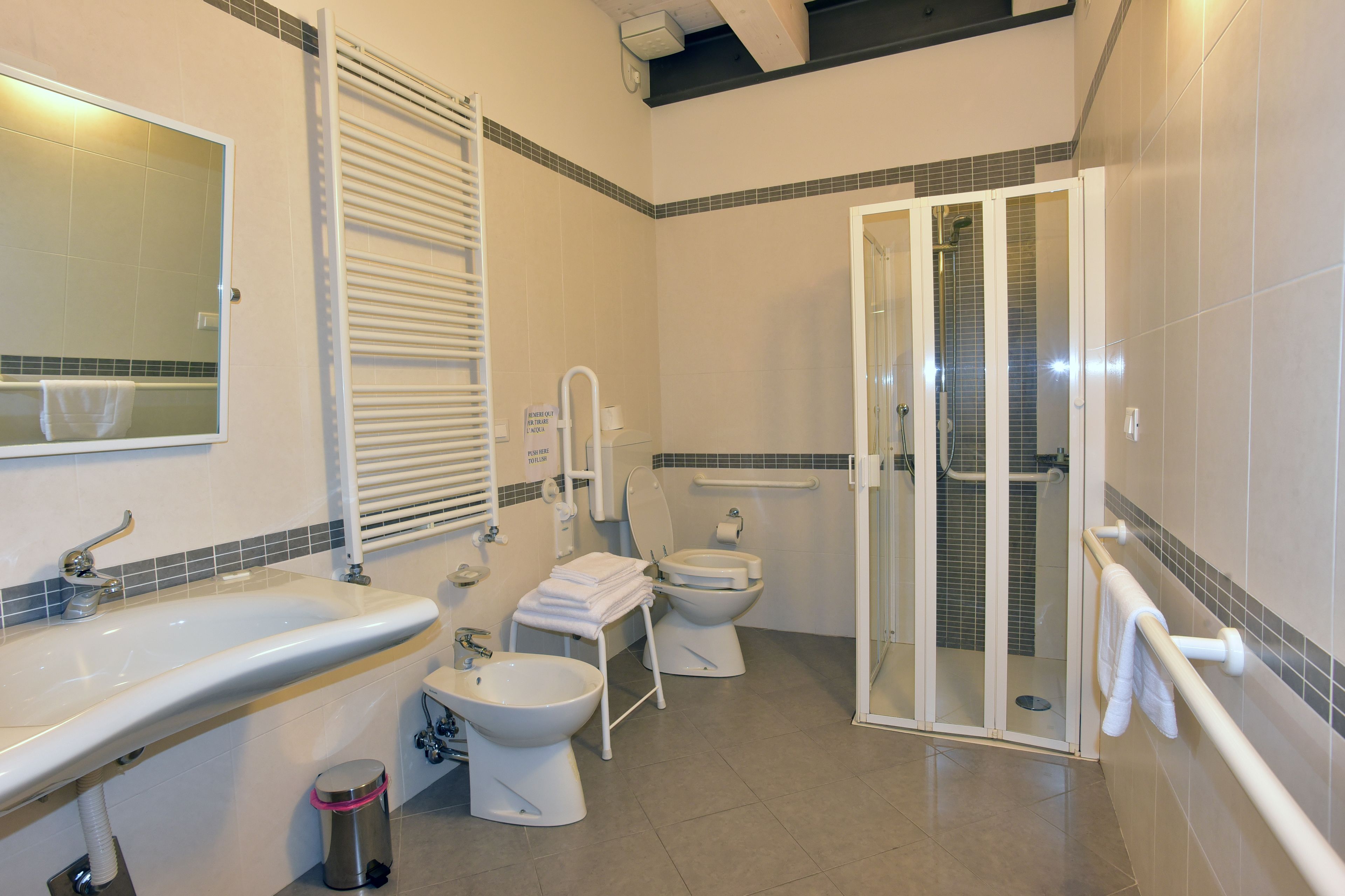 Un baño con lavamanos, inodoro, bidé y cabina de ducha de vidrio.