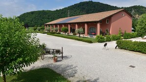 Ein Gebäude mit roter Fassade, Solaranlagen auf dem Dach und einer Schotterauffahrt.