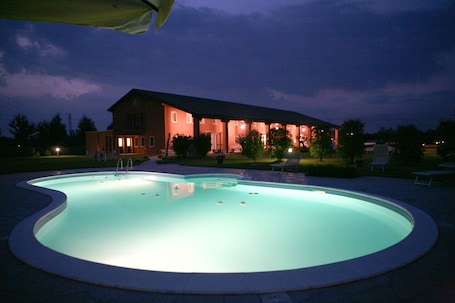 Una piscina al aire libre, sillones reclinables de piscina