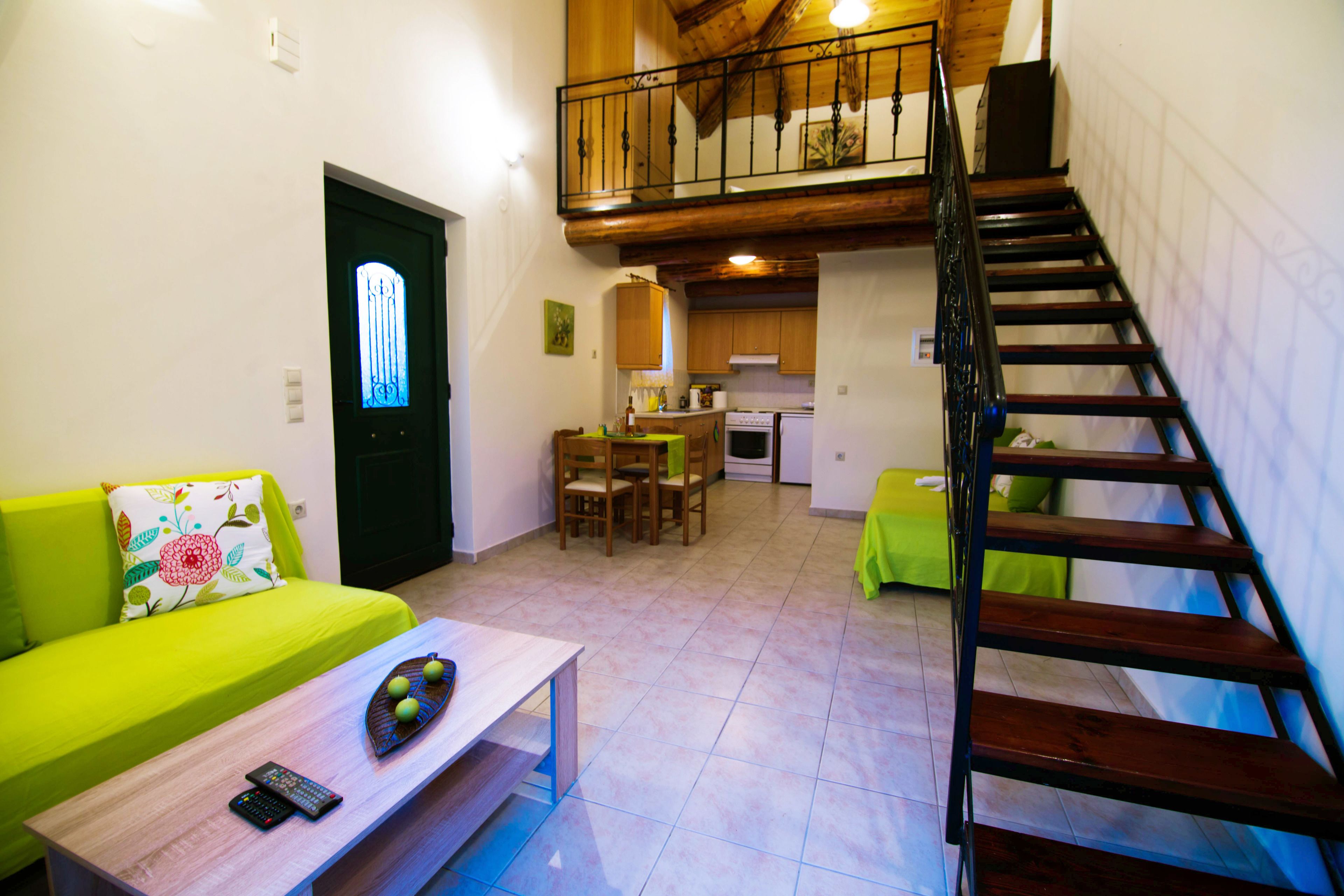 A compact living space with a dining area, a kitchen, and a staircase.