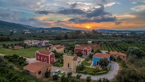A residential area with houses, a soccer field, and a vineyard. - Athousakis Village (Chania)