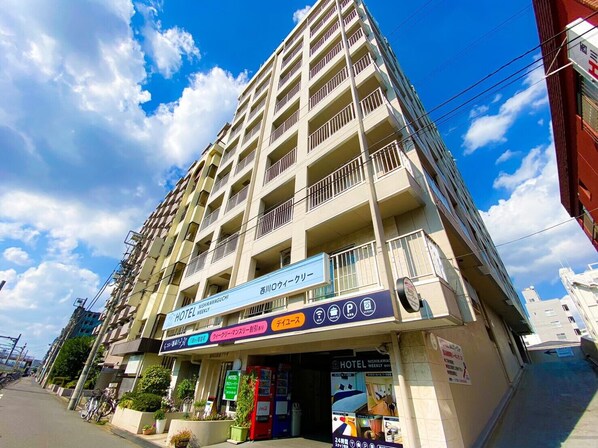 A multi-story hotel with a sign indicating it is a weekly hotel. - HOTEL Nishikawaguchi Weekly (Kawaguchi)