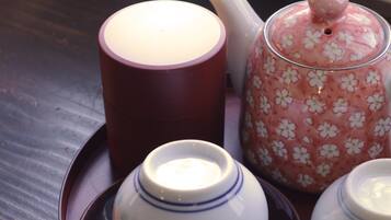 A tea set with a teapot, a cup, and a sugar bowl on a tray.