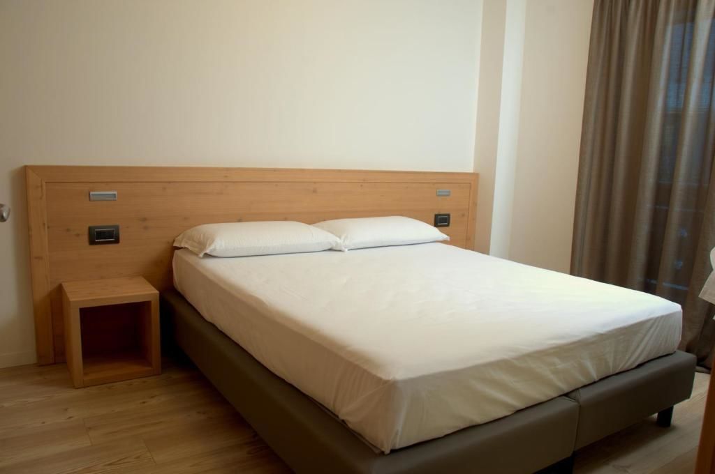 A single bed with a wooden headboard and a small bedside table.
