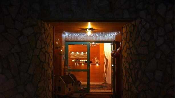 A stone-walled entrance with a door leading to a warmly lit interior. - Relais Fior di Bosco (Folgaria)