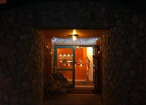 A stone-walled entrance with a door leading to a warmly lit interior. - Relais Fior di Bosco (Folgaria)