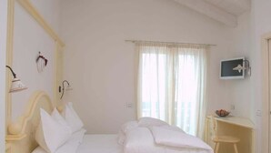 A bedroom with a bed, a desk, and a television. - Relais Fior di Bosco (Folgaria)
