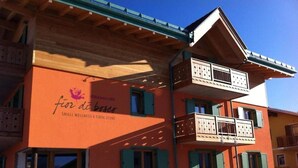A building with a sign reading "for dibiaco SMALL WELLNESS & TOL STUBE". - Relais Fior di Bosco (Folgaria)