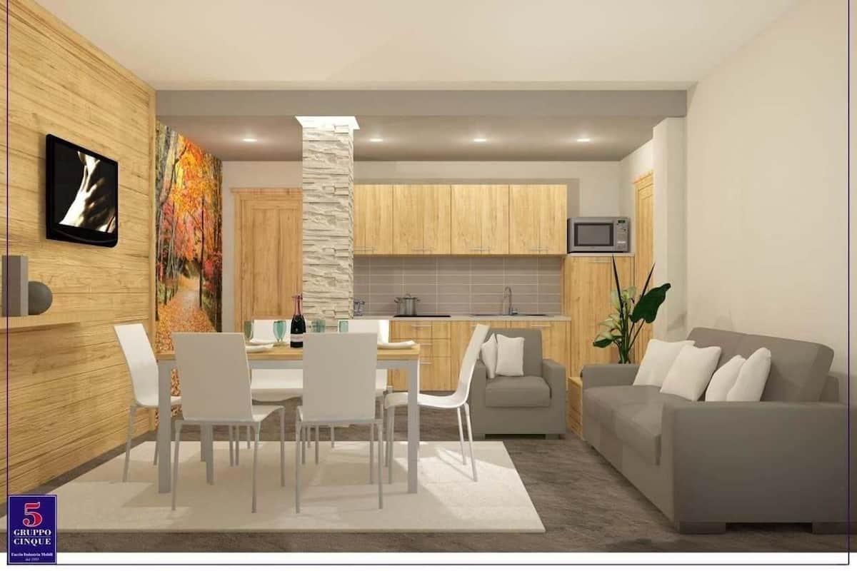 Una cocina moderna con armarios de madera, un pilar de piedra y un comedor con sillas blancas y una mesa.
