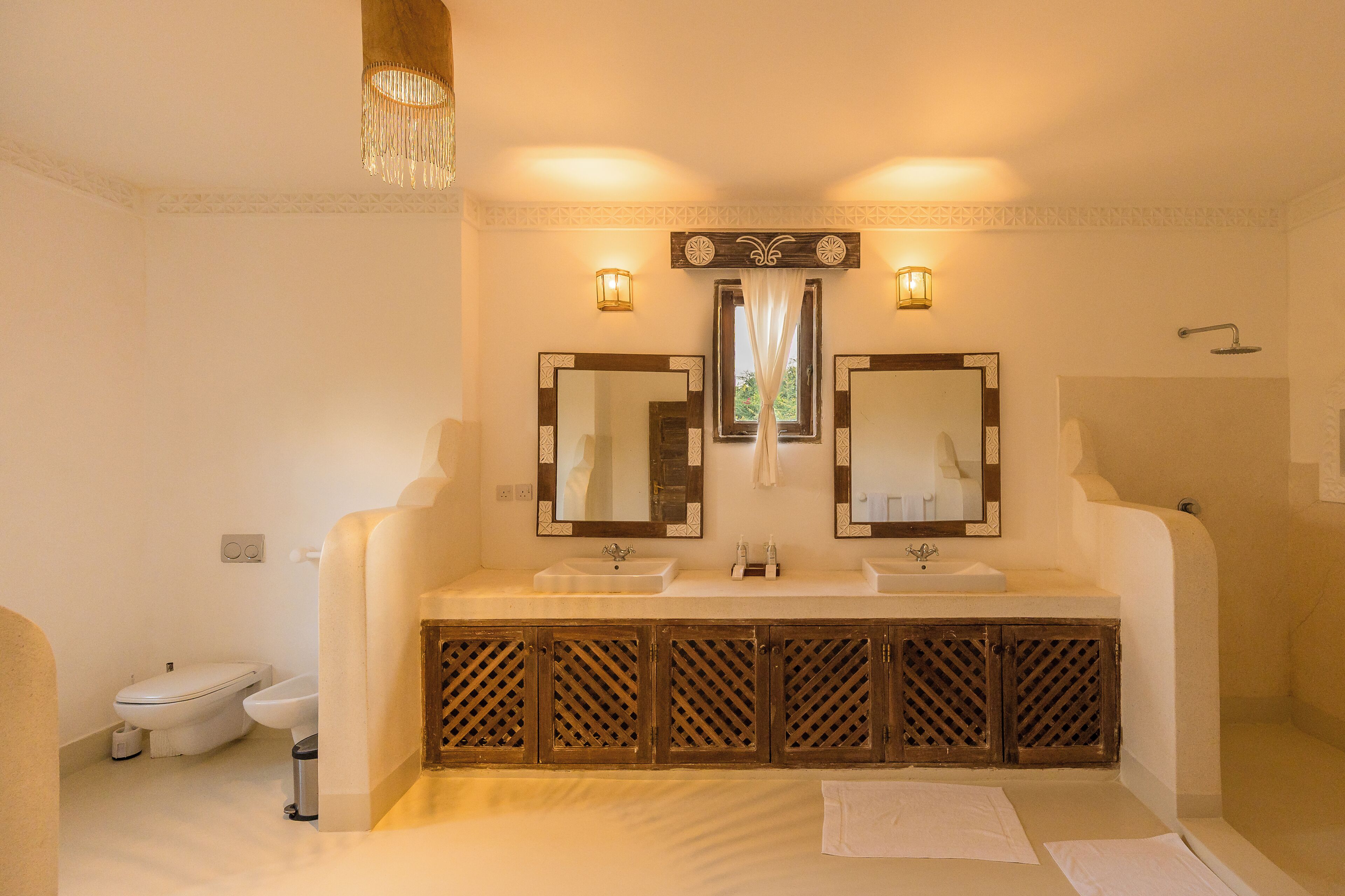 A bathroom with two sinks, a toilet, and a shower.