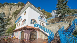 A white building with blue railings and a stone staircase leading up to it. - Elegant & Panoramic Villa with Sea View Solarium (Furore)