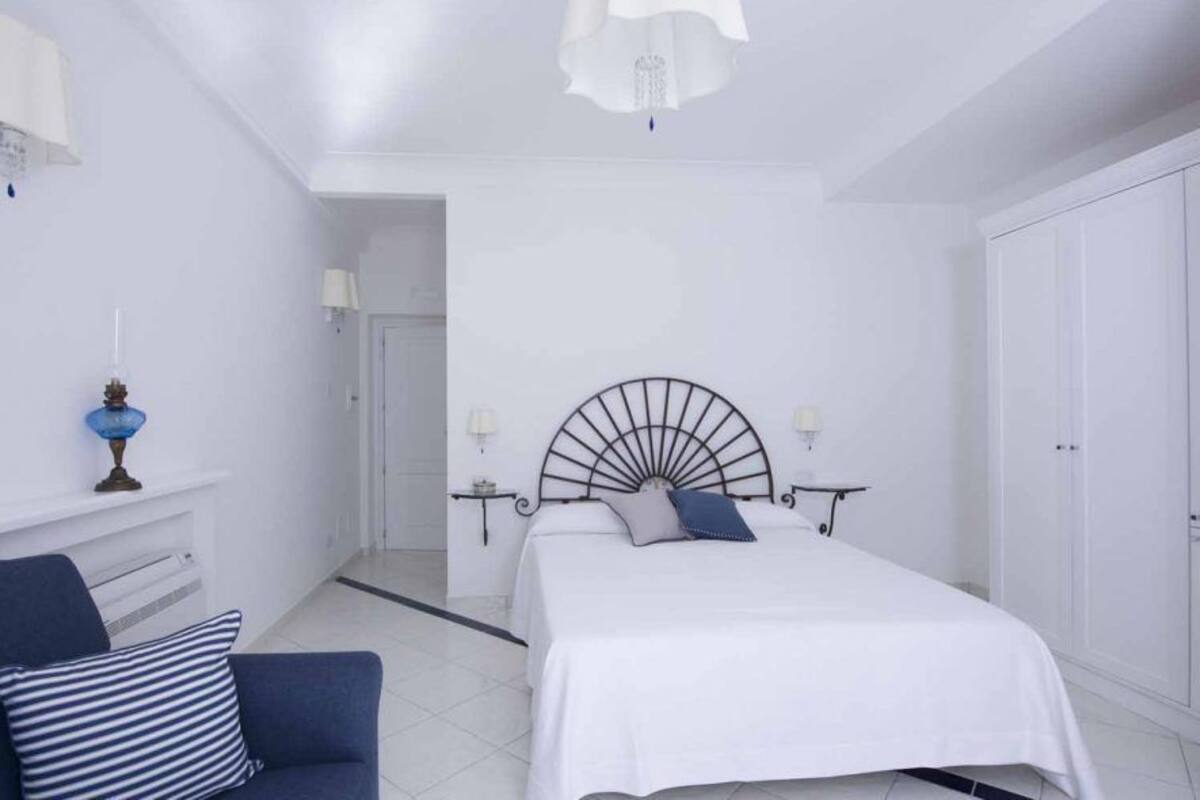 Un dormitorio con una cama, un sofá azul y un armario blanco.