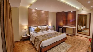 A modern hotel bedroom with a large bed, bedside tables, a mirror, and a built-in wardrobe. - Hotel Lilac (Kota)