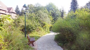A cobblestone path leading through a garden with a bench and a street lamp. - Cy Twombly -. Villa-Hufeland in Berlin, quiet, 25 minutes by S-Bahn to the center (Berlin)