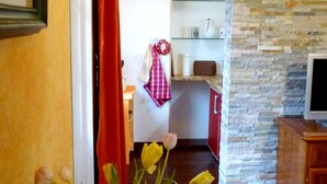 A cozy living room with a wooden table, a vase of flowers, and a stone wall. - Cy Twombly -. Villa-Hufeland in Berlin, quiet, 25 minutes by S-Bahn to the center (Berlin)