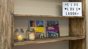 A shelf with a motivational sign, two glass jars with candles, and books. - Casa Maca Guest House Boutique - Adults Only (Barcelona)