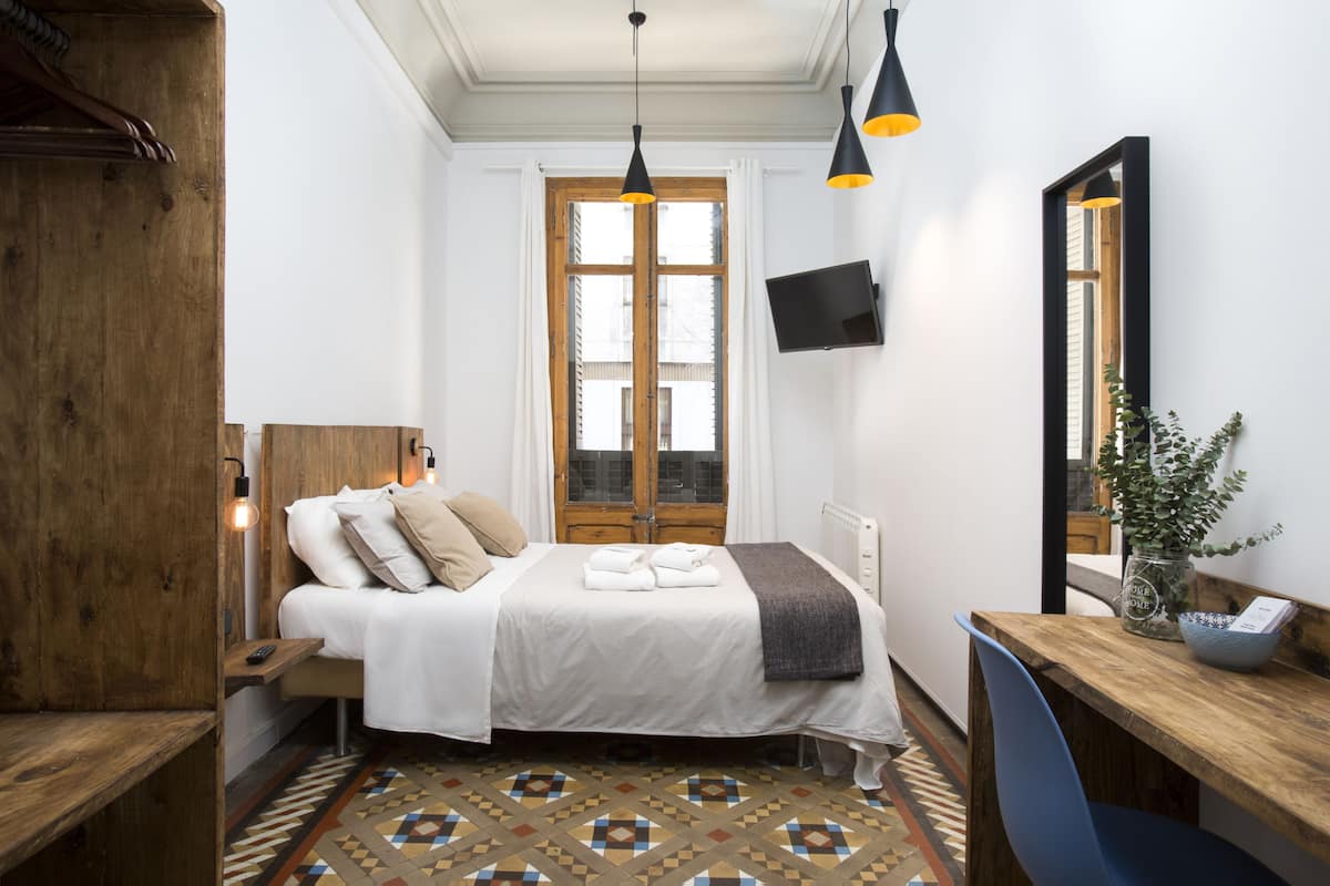 Habitación doble económica, baño compartido | Minibar, escritorio, cortinas blackout y tabla de planchar con plancha