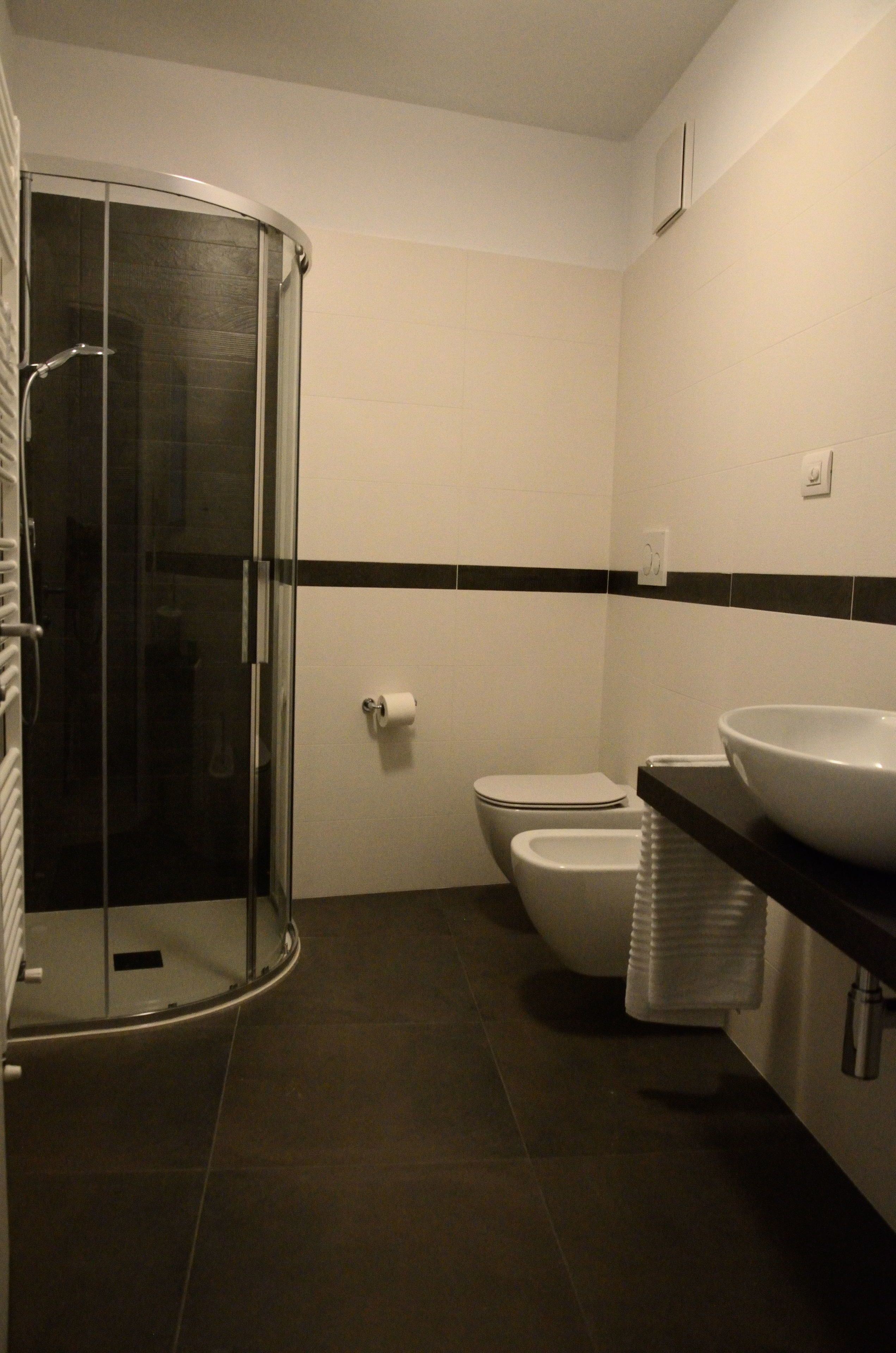 Ein Badezimmer mit Duschkabine, Toilette und Waschbecken.