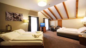 Ein Hotelzimmer mit zwei Betten, einem Schreibtisch, einem Sessel, einem Fernseher und einem Gemälde an der Wand.