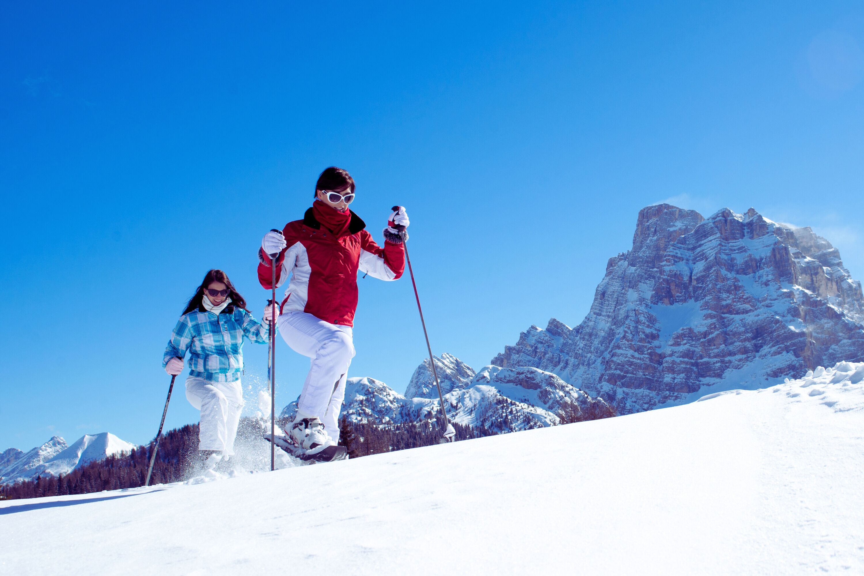 A snowy mountain landscape with skiers.