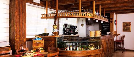Un rústico espacio de bar con muebles de madera, una barra con botellas y una cafetera.
