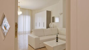 A modern living room with a sectional sofa, a coffee table, and a chandelier.