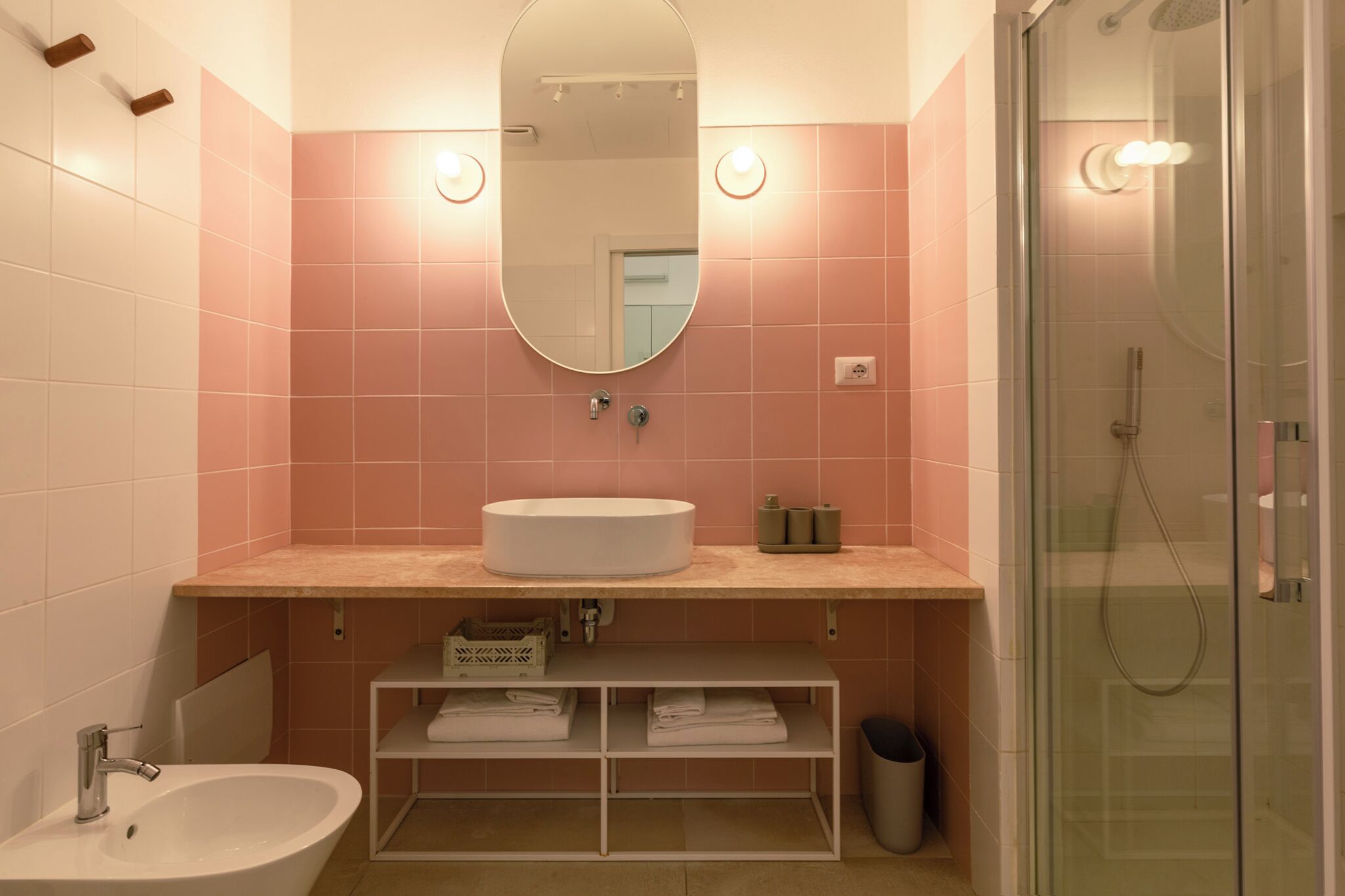 Un baño con lavamanos, espejo y ducha.