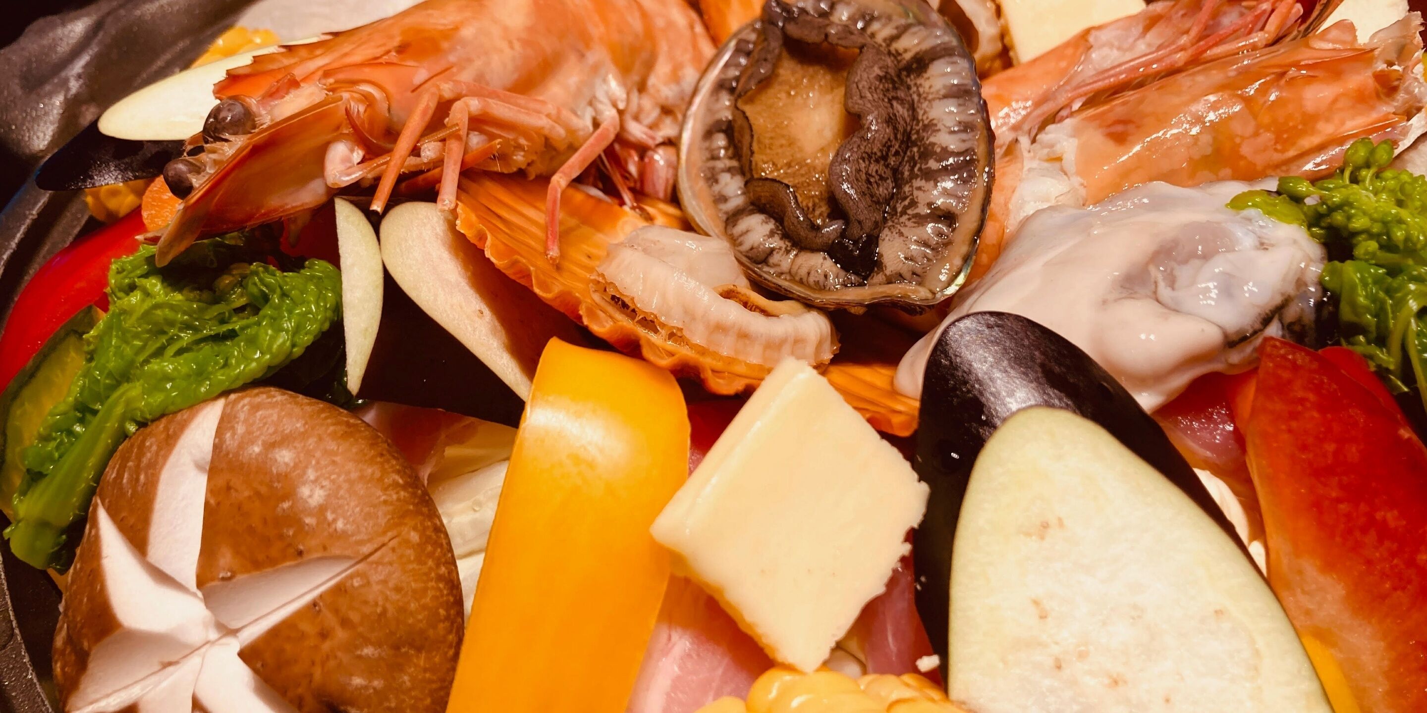 Uma seleção de frutos do mar com camarão, mexilhões e diversos vegetais.