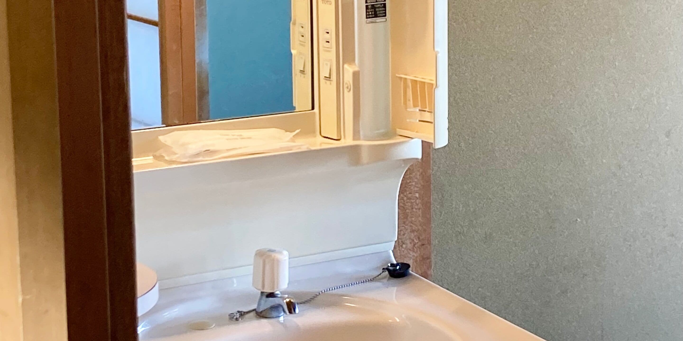 A bathroom with a white sink, a mirror, and a towel rack.