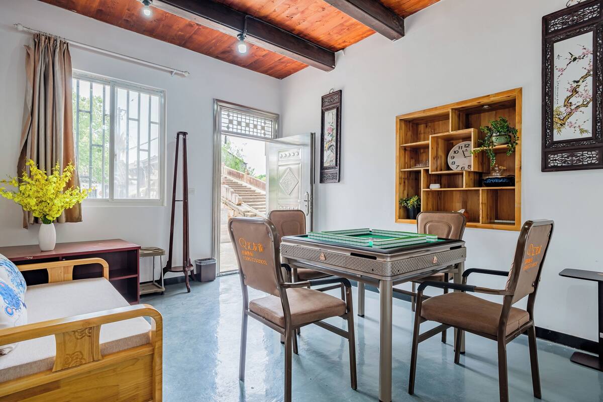 Una habitación con mesa de billar, sillas, cama, escritorio y estantería.