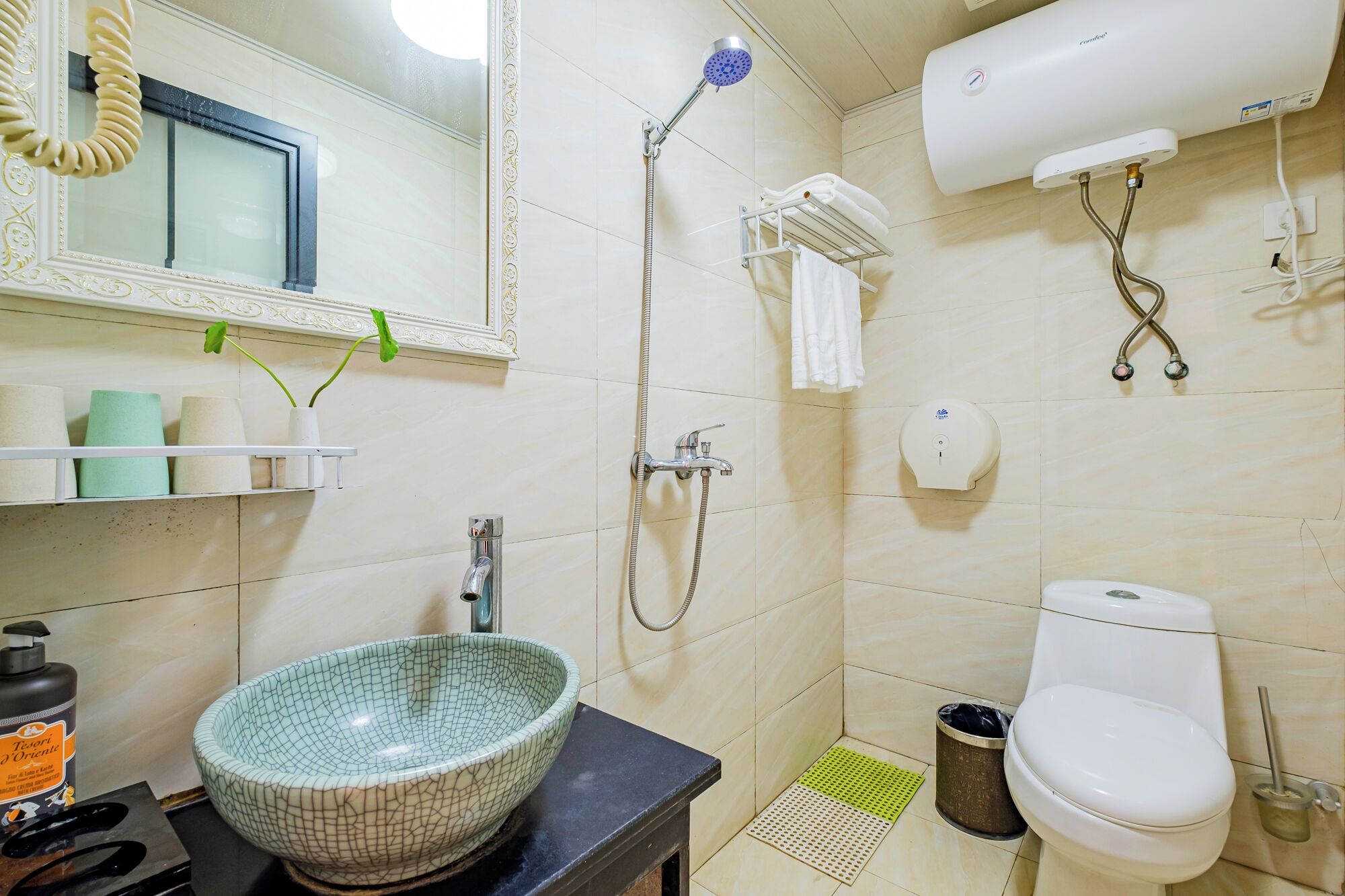 Un baño con lavamanos, inodoro, ducha y espejo.