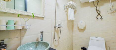 Un baño con lavamanos, inodoro, ducha y espejo.