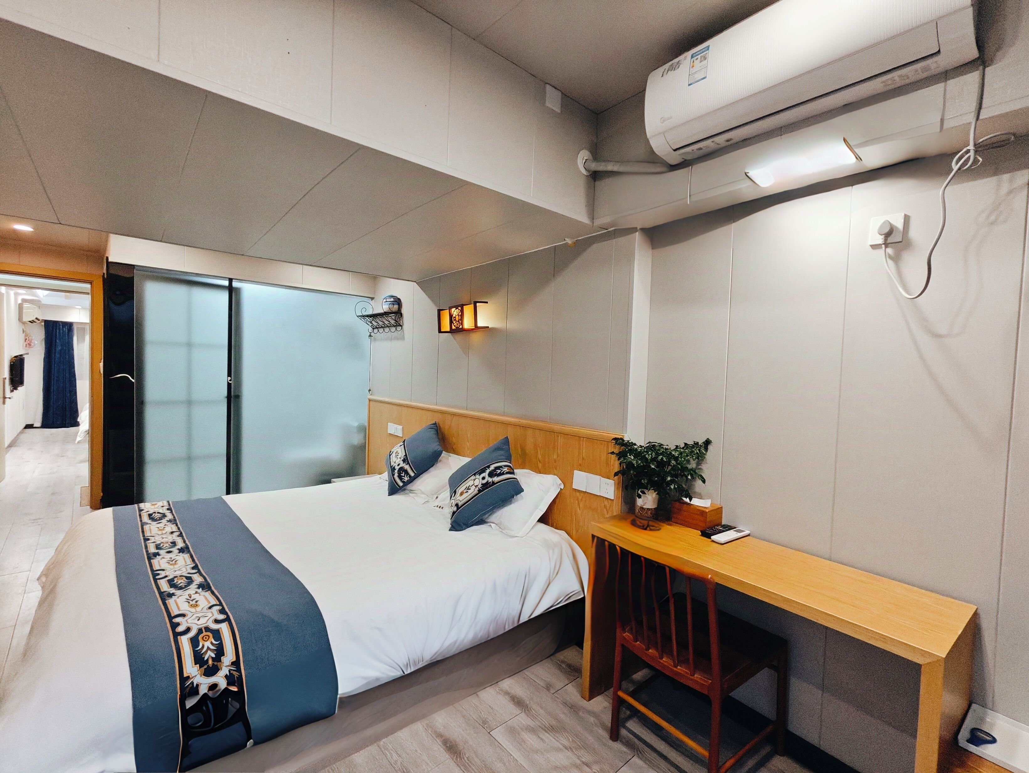 A modern bedroom with a bed, bedside table, and a desk.