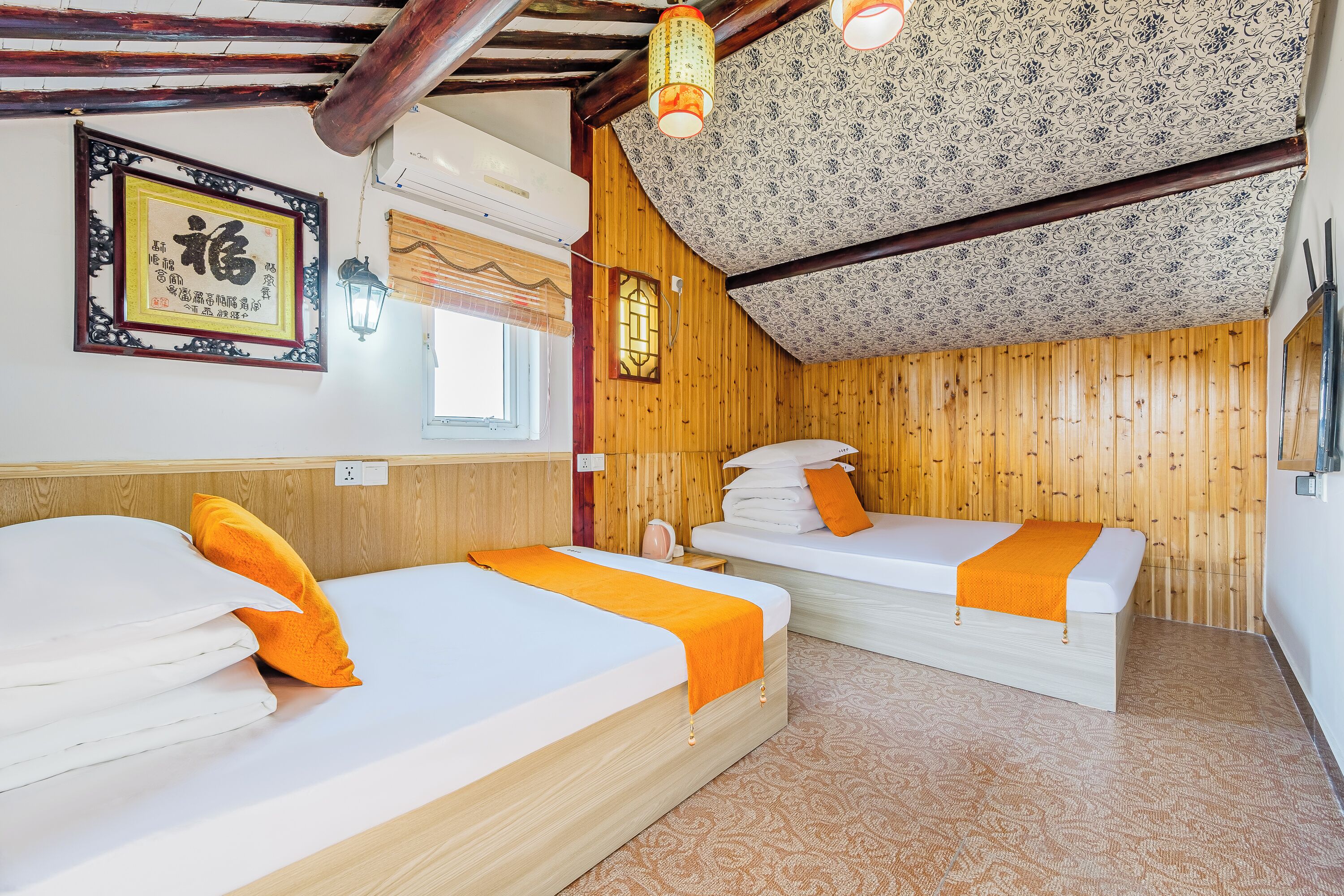 Habitación con dos camas, paredes de madera, techo estampado y un cartel enmarcado en la pared.
