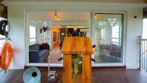 A room with a wooden podium, a sofa, and a large window. - Beachparadise  Daycruise houseboat (Ambalapuzha)