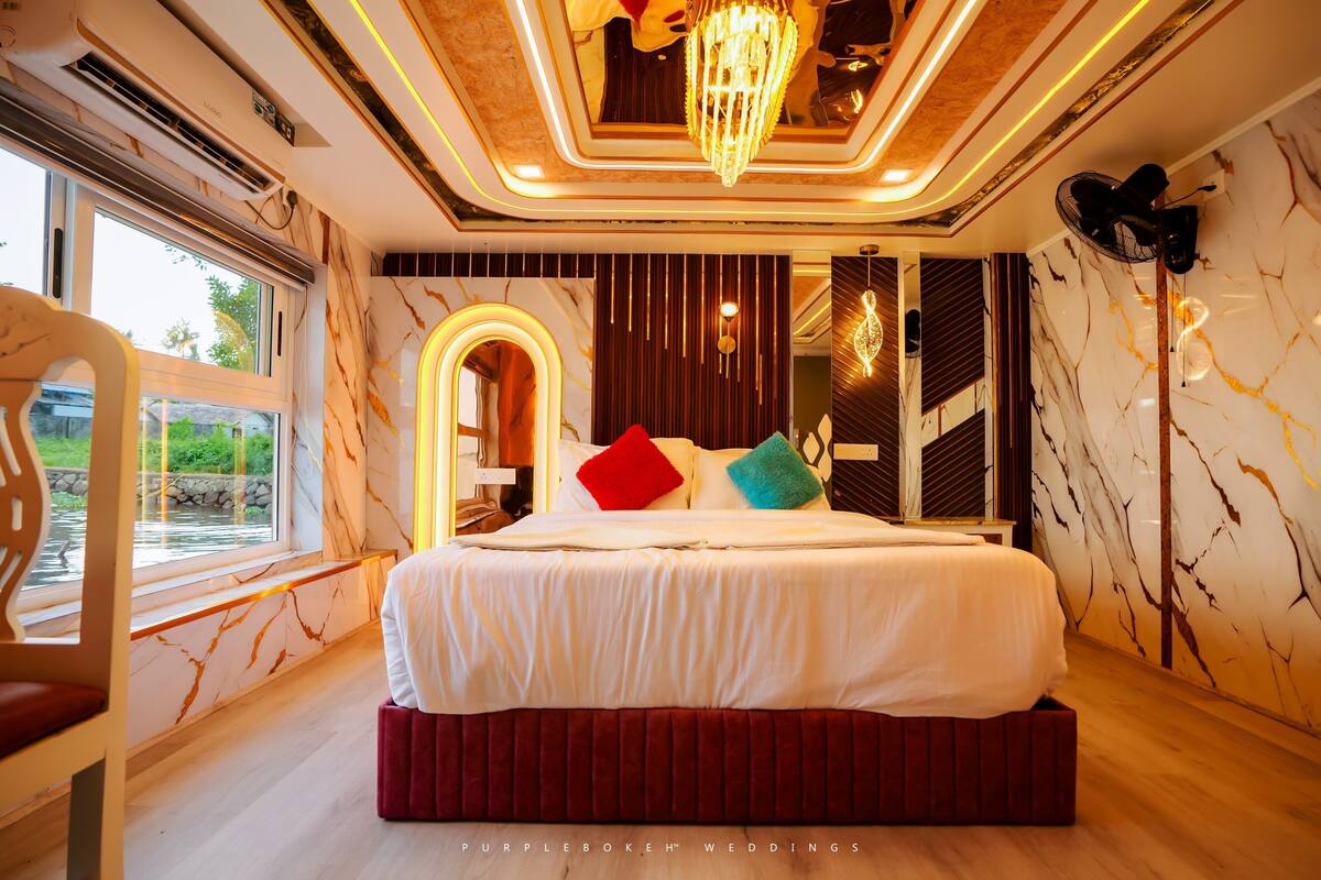 A modern bedroom with a large bed, a view of a garden, and a chandelier.