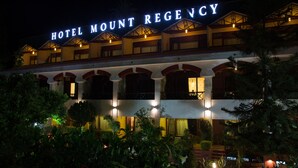 Un hôtel dont l’enseigne, bien visible, porte l’inscription « HÔTEL MOUNT REGENCY ».