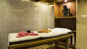 Cozy retreat with a wooden bench bed, adorned with a white sheet and a pink towel, and a decorative statue above.