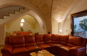 Ein geräumiger Wohnbereich mit einer braunen Ledersitzgruppe, einem Couchtisch und einem Essbereich mit Tisch und Stühlen.