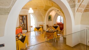 An interior with arched ceilings and a dining area with tables set for a meal. - B&B L'Antica Rimessa (Lecce)