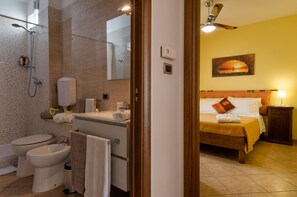 Ein Badezimmer mit Dusche, Toilette, Bidet und Waschbecken.