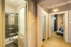 A modern bathroom with a glass shower enclosure, a toilet, and a walk-in shower.